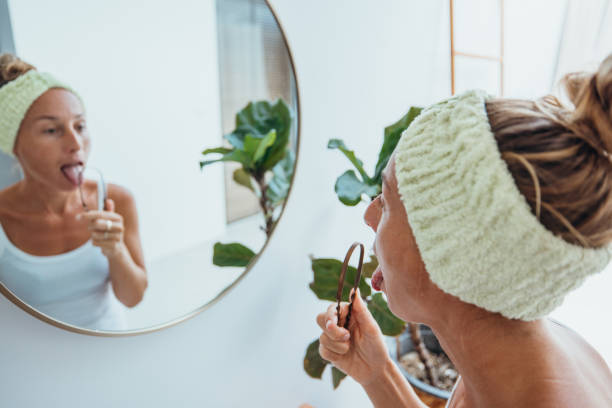 istock Woman Practicing Tongue Cleaning in Modern Bathroom 2193290944