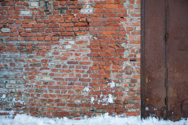 istock Rustic brick wall with a rusty metal door showcases industrial decay 2193291218