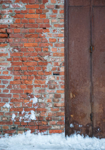 istock Rustic brick wall with a rusty metal door showcases industrial decay 2193291297