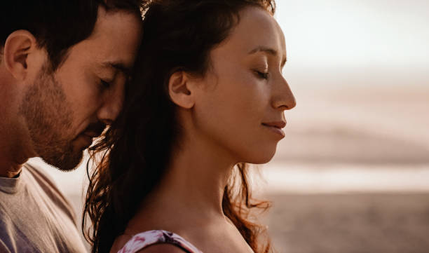 istock Loving couple standing close together on a beach at dusk 2193291563