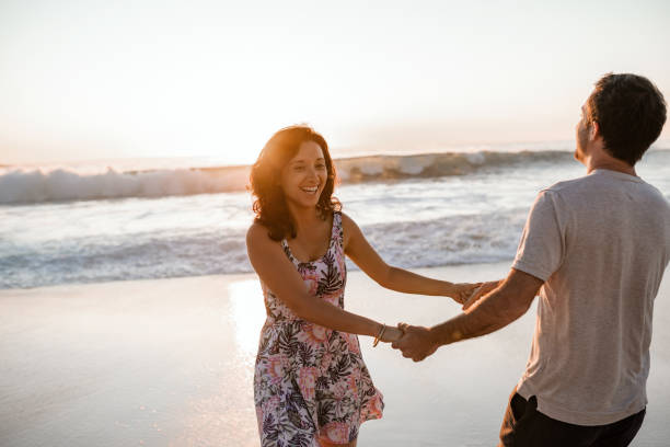 istock Laughing young couple having fun at the beach at sunset 2193291722