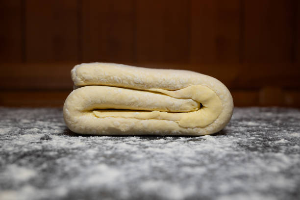 istock Homemade, folded, square, pastry dough with flour dusting on a kitchen table. Close up shot, no people 2193291904