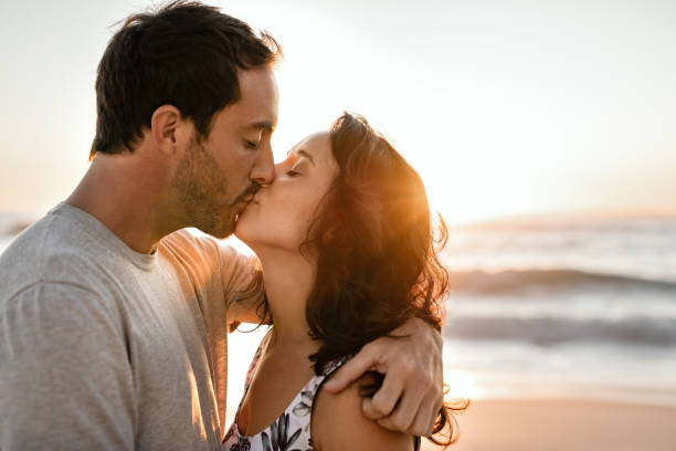 istock Loving young couple kissing on a beach at sunset 2193291921