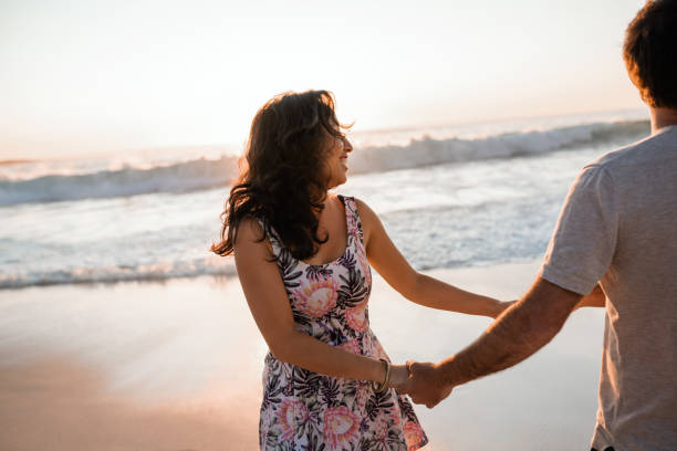 istock Young couple having fun together on a beach at sunset 2193292891