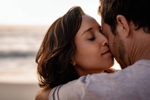 istock Affectionate woman standing in her husband's arms on a beach 2193292919