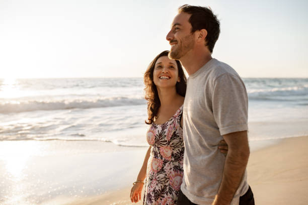 istock Loving young couple walking together along a sandy beach 2193292966