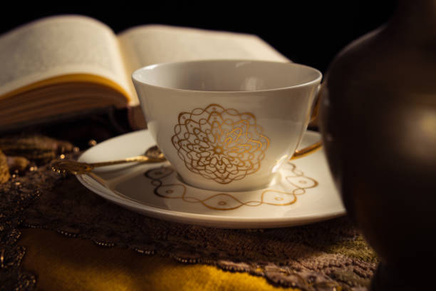 Tea in porcelain cup and journal on wooden table, part of mental health routine  - journal for therapy session - copy space for text, concepts and ideas, healthy lifestyle