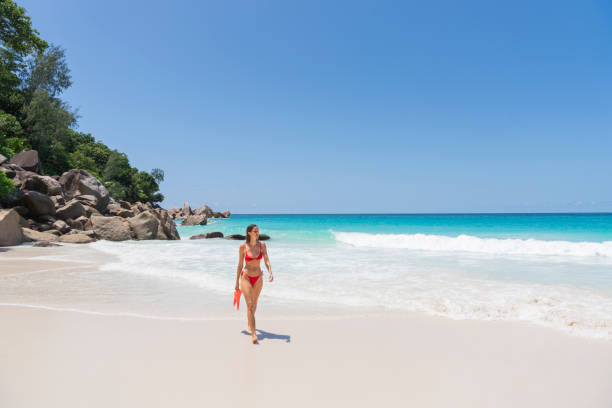 istock Young woman on tropical beach with flippers 2193297135
