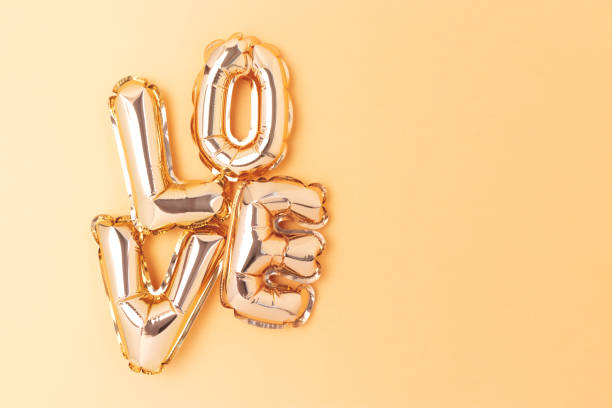 istock Word Love. Inflatable balloons on a golden background. 2193297400