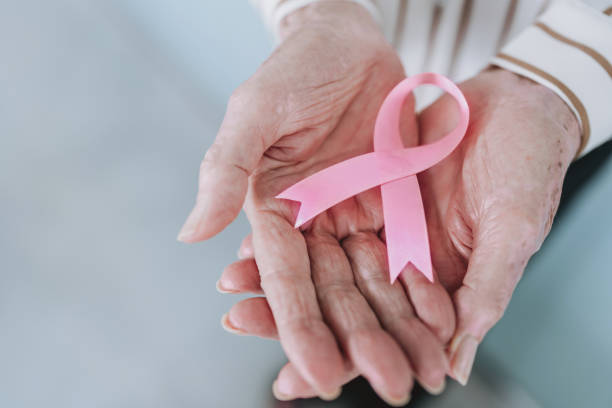 istock Hands holding pink ribbon, breast cancer awareness 2193298646