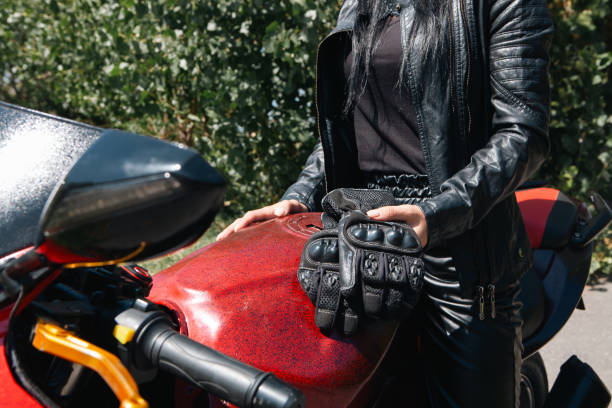 Motorcyclist with helmet in his hands. Dark background