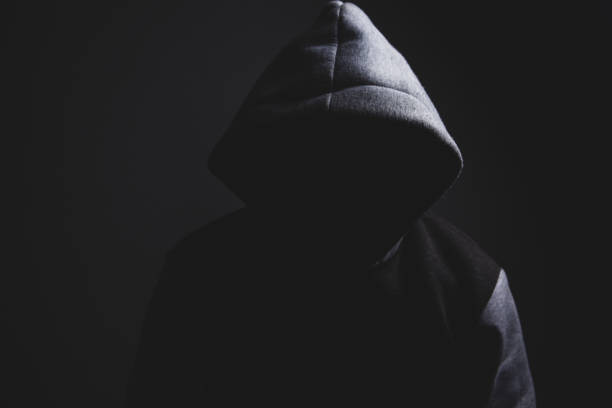 man wearing hood in dark room, horror concept