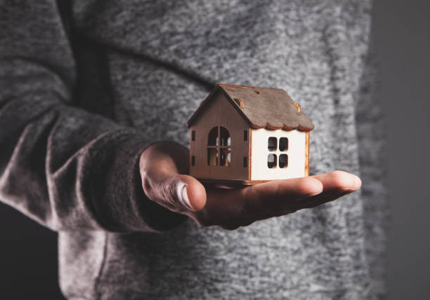 istock male hands holding small house. 2193304274