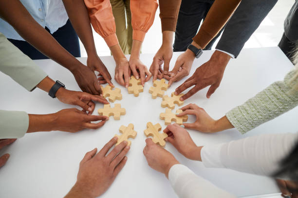 Diverse employees connect jigsaw puzzle pieces
