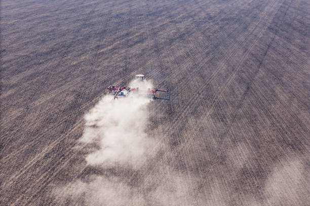 Tractor plowing field and add nitrogen fertilizer for agricultural crops like as corn and wheat, aerial view  (Voronezh region, Russia)