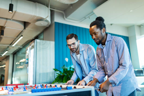 istock Colleagues relaxing in office playing foosball 2193306341