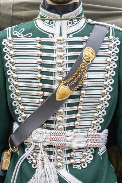 Close-up of a traditional Hungarian Hussar uniform, showcasing intricate silver embroidery, gold embellishments, and a decorative sash.