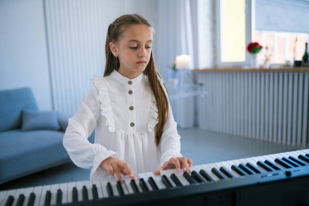Girl playing electric piano. Child practicing on the modern electric piano at home. Music lesson