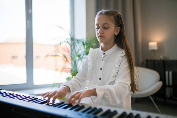 istock Girl practices on synthesizer at home 2193306899