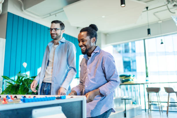 istock Colleagues relaxing in office playing foosball 2193307440
