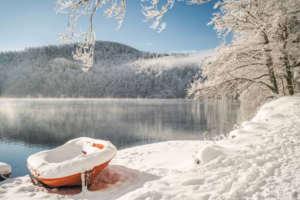 istock Serene Winter Landscape with Snow-Covered Red Boat 2193307479