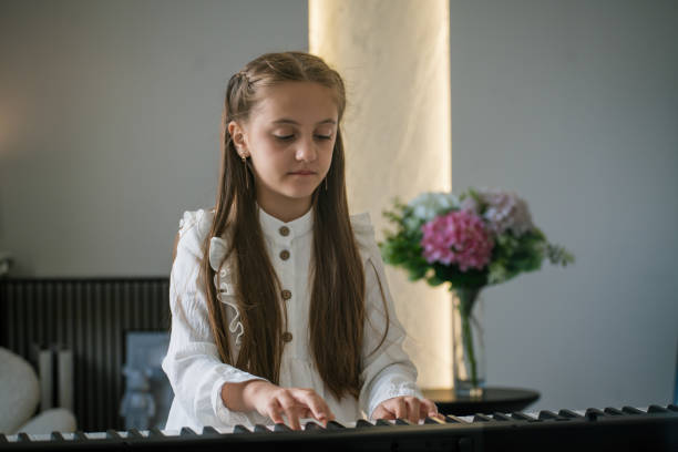 Young girl is immersing herself while playing the digital piano in a beautifully bright and stylish living space
