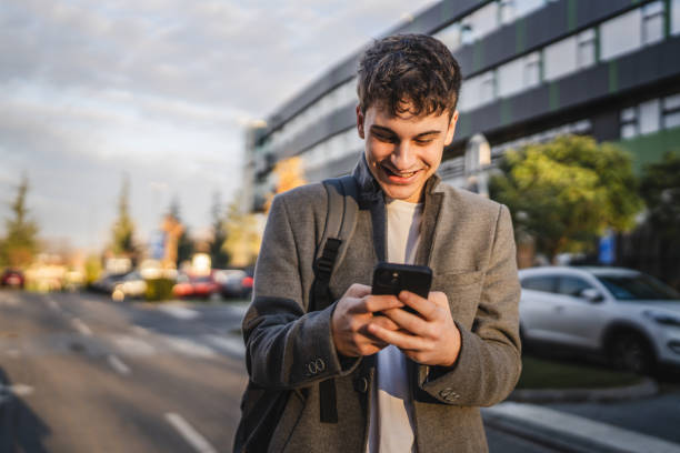 istock young adult man stand and use mobile phone in front modern buildings 2193309190