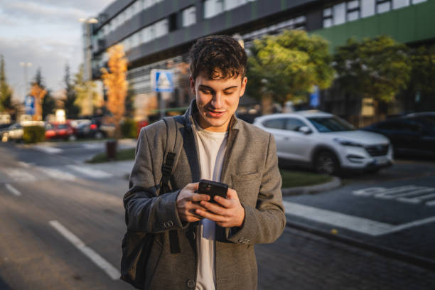 istock young adult man stand and use mobile phone in front modern buildings 2193309800