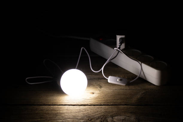 istock An energy-saving light bulb is on the wooden floor near the socket 2193309843