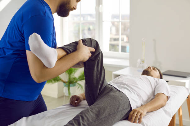 istock Chiropractor, osteopath or physiotherapist treating patient's pain and examining knee flexion 2193313262