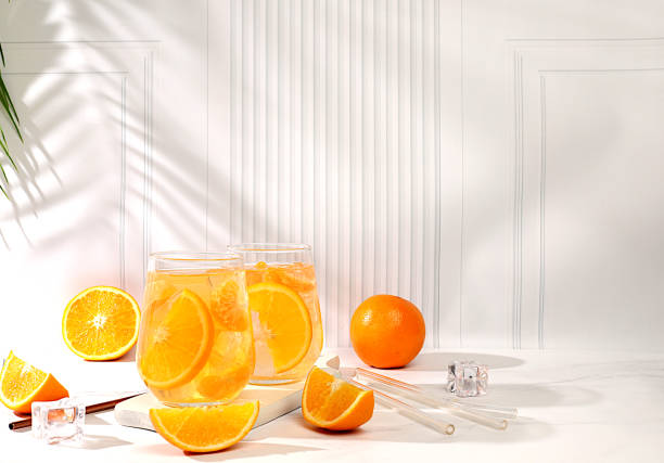 istock Orange juice and oranges on elegant kitchen table with long hard shadows. Modern still life with citrus fruits, minimal detox diet concept, summer vitamin drinks, selective focus, 2193313276