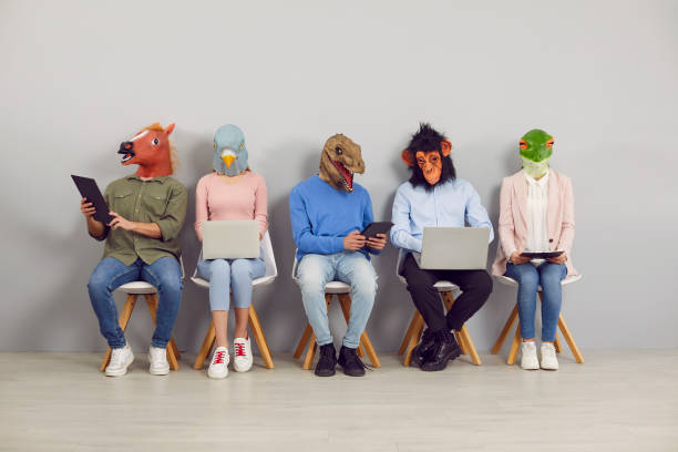 People in funny animal masks waiting in line and using laptop and tablet computers