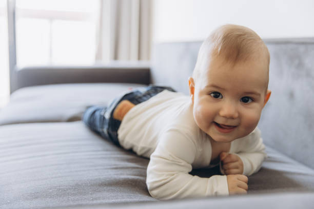 istock Adorable baby lying on sofa and smiling 2193317403