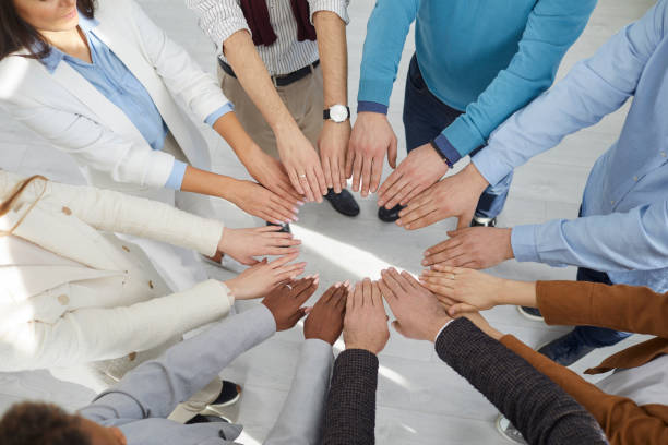 istock Top view multiracial team peoples outstretched hands standing in circle symbolizing inclusive 2193318413