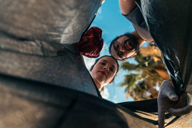 istock A man and a woman are throwing garbage into a garbage bag 2193321254