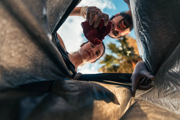 istock Two people are throwing trash into the trash bag, photo from below 2193321317