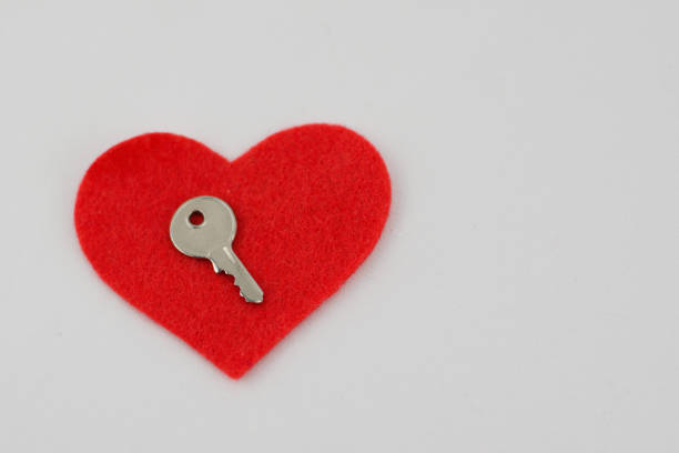 Heart shape key with message in girl hand over blurred background, love message, key to someone heart, love and romance concept, valentine day