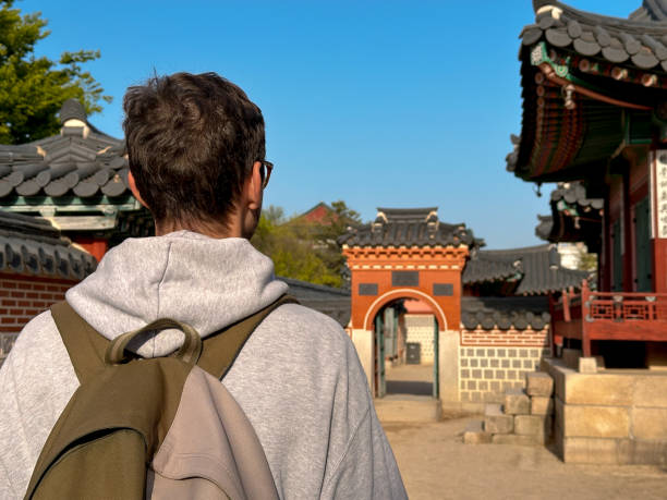 istock Traveler exploring a traditional Korean palace with intricate architecture 2193329294