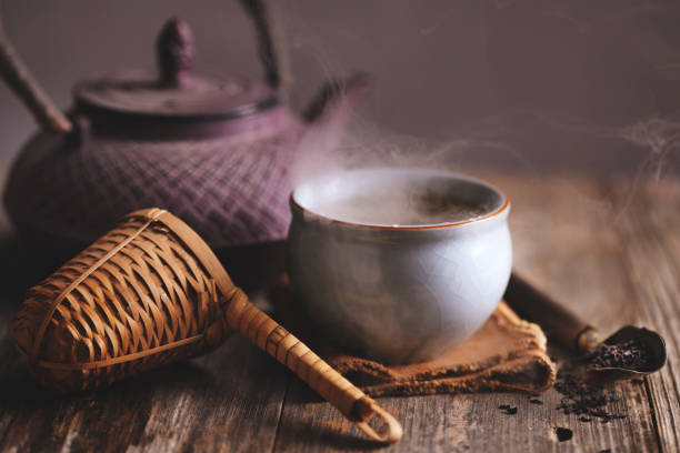 Hot black tea with metal tea pot and bamboo strainer