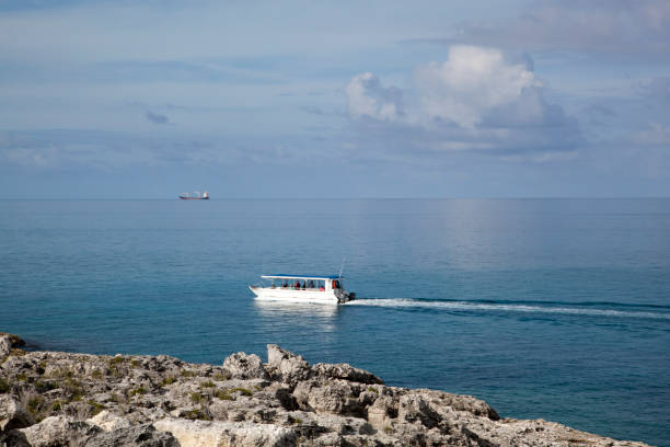 The view of a tourist motorboat passing by along Little Stirrup Cay shore (Bahamas).