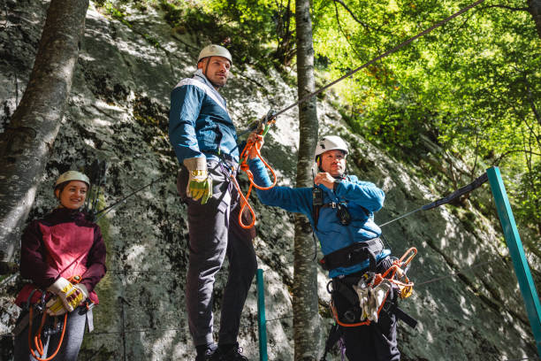 istock Group of Adventurous Friends Preparing for Zipline Activity in Forest 2193342028