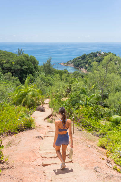 istock Young woman hikes down jungle trail 2193342560