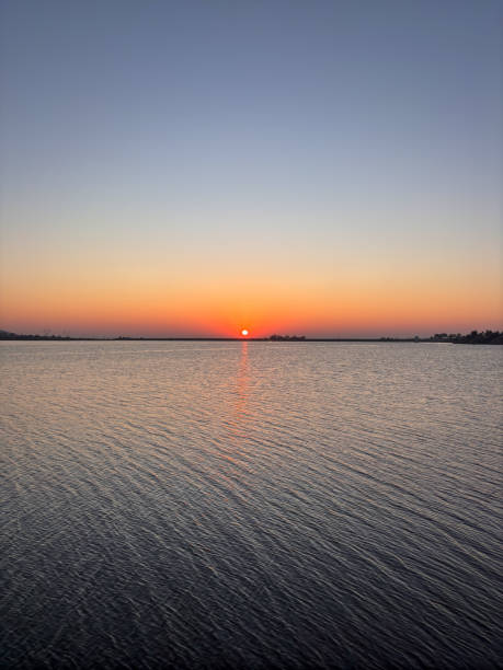 istock The sun is setting over the water, creating a beautiful and serene atmosphere 2193346441