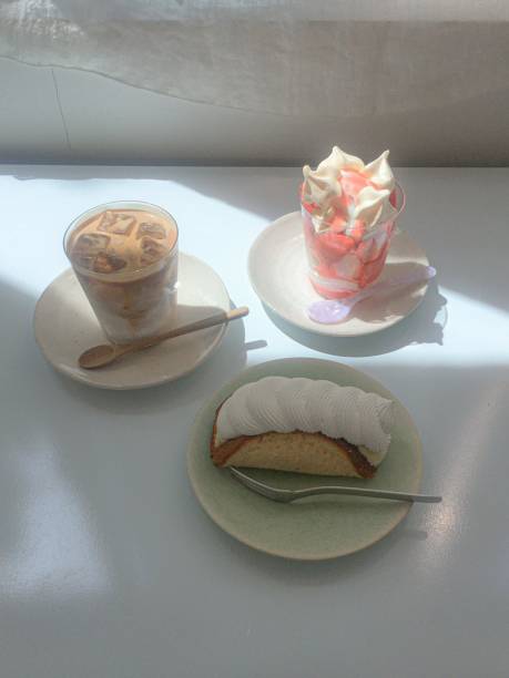 A delightful assortment of desserts displayed in a cozy cafe setting, featuring cakes, pastries, and sweet treats on elegant plates, creating a warm and inviting atmosphere.