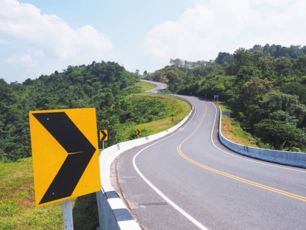 istock warning arrow sign on a dangerous curve road across mountain. 2193355418
