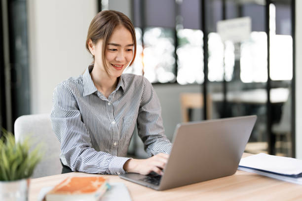 istock Young business woman working on laptop computer at her desk office. 2193363122