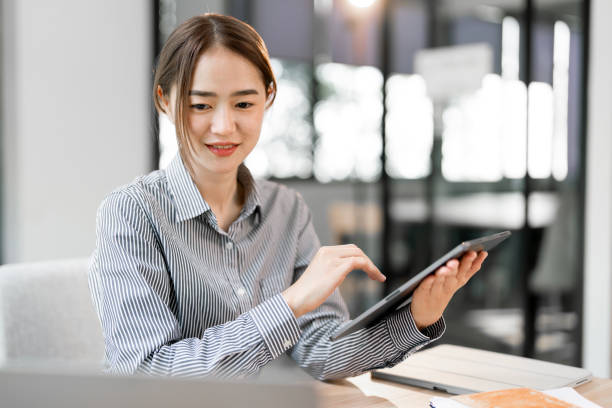 istock young beautiful joyful woman smiling while working with laptop in office 2193363608