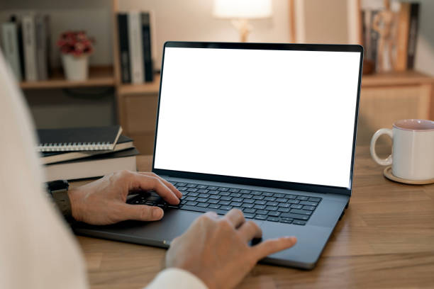 istock Close-up image of a man working on laptop computer at a table, typing on the laptop keyboard. the laptop with a white screen mockup 2193363674
