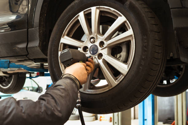 istock Mechanic changing car wheel using impact wrench in garage 2193364595