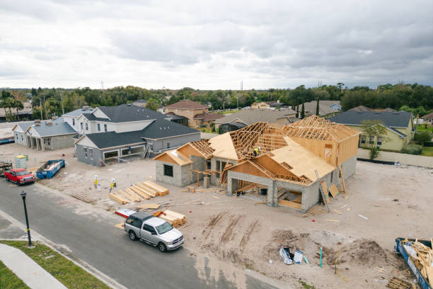 istock New Construction Homes - Orlando Florida - Developing Neighborhood - Three Houses Under Construction - Worker Adding Roof 2193364969